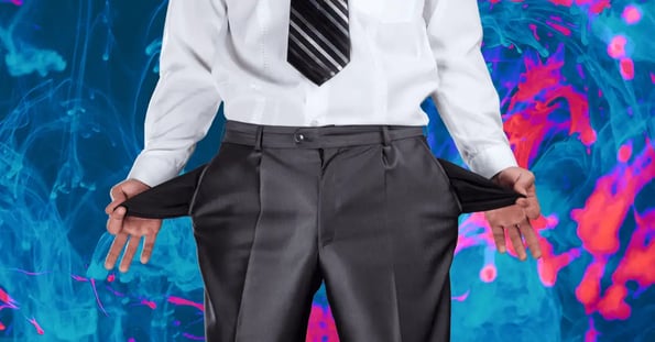 A person wearing a button-down shirt, slacks, and a tie turns out their pockets to show they are empty.